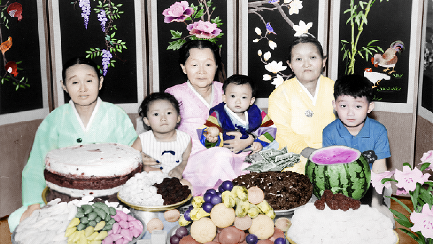 A hand-coloured photograph of a family celebrating ‘doljanchi’, from Lee Grant's series of found images titled “Lost and Found: Chromatic Dialogues”